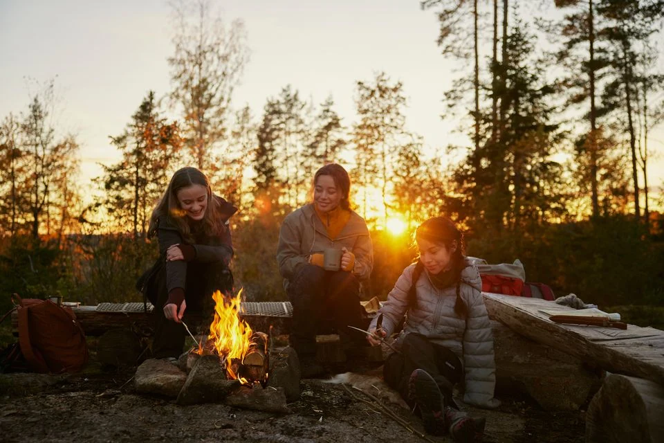 Unge rundt bål i skogen